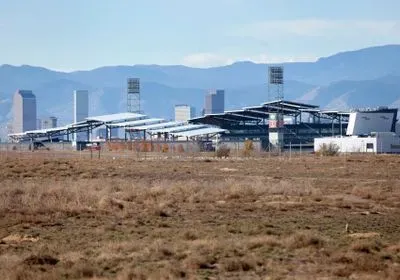 Dicks Sporting Goods Park stadium from a distance with mountains in the background